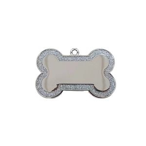 Macro shot of bone-shaped silver pet ID tag with sparkling diamond-encrusted edges