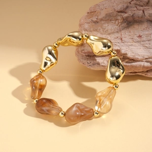 Detailed shot of amber resin and golden irregular metal beads on a vintage beaded bracelet