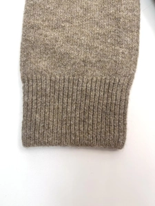 Detailed close-up of light brown knit cuffs with premium ribbed texture and soft wool blend