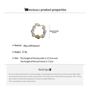 Détails du bracelet en perles baroques avec breloque dorée et fermoir mousqueton