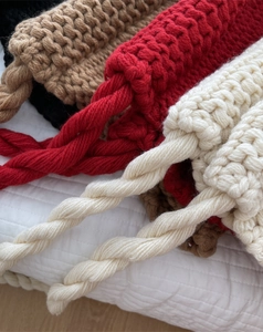 Détail des textures de tricot torsadé épais en noir, marron, rouge et beige