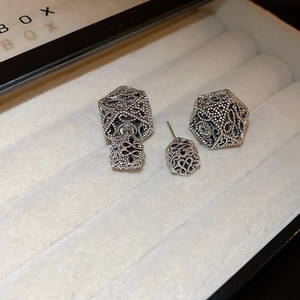 Detail of hollow geometric silver earrings with two-way wear structure on jewelry box