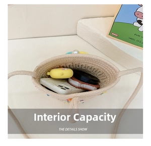 Internal capacity of woven flower crossbody bag showing phone and accessories