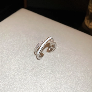 Detailed macro view of an X-shaped open ring with cubic zirconia and white enamel inlay