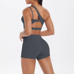 Detail view of one-shoulder sports bra with multi-strap crisscross back and high waist shorts