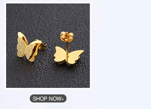 Macro shot of gold butterfly stud earrings featuring matte and polished metal finishes