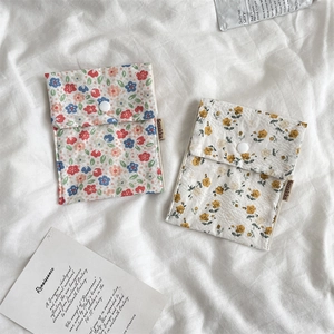 Detailed view of floral cotton sanitary pad storage bags with secure snap button closure