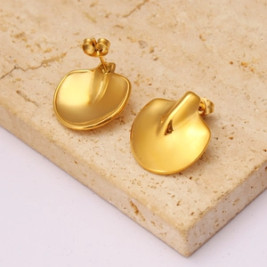 Irregular petal-shaped gold stainless steel earrings on a textured stone surface