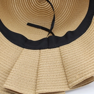 Straw sun hat detail showing the adjustable inner ribbon and sweatband in beige
