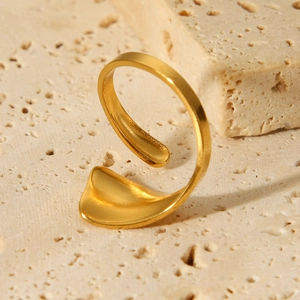 Close-up of a 18K gold-plated geometric stainless steel ring on a beige stone background