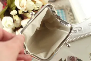 Close-up of vintage metal clasp coin purse showing beige lining and interior space