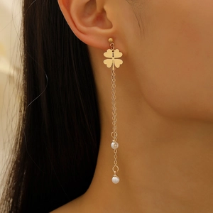 Elegant gold long tassel earrings with clover motif and white pearls on female model