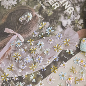 Detailed close-up of 3D embossed floral nail stickers with Daisy and Sunshine motifs