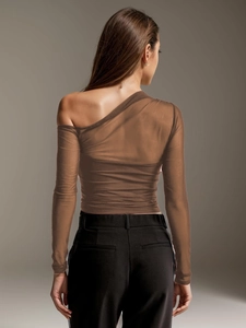 Detail of sheer brown mesh patchwork on a long sleeve one shoulder asymmetric top