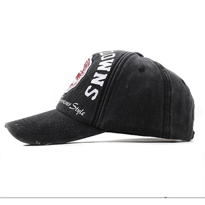 Side view detail of vintage washed black baseball cap with white embroidery and distressed brim