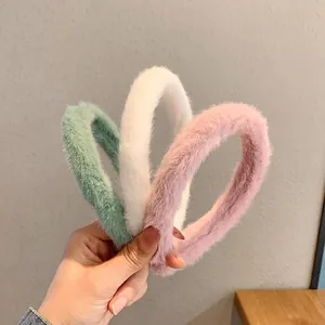 Plush faux fur headbands set in mint green, white, and pink for a soft winter look