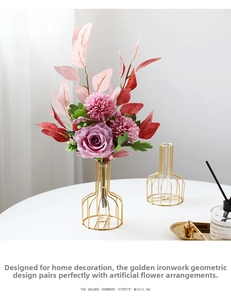 Detail of gold geometric metal vase with silk roses and chrysanthemums in glass tube
