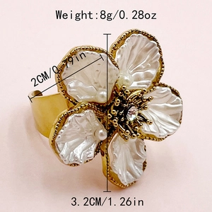 Detail of flower ring featuring white crystal petals and gold-plated floral texture