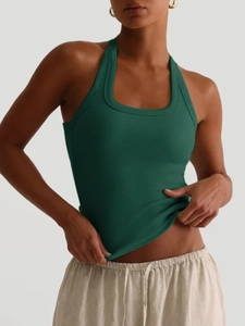 Nahaufnahme von grünem geripptem Neckholder-Yoga-Top mit figurbetonter Passform und weichem Licht