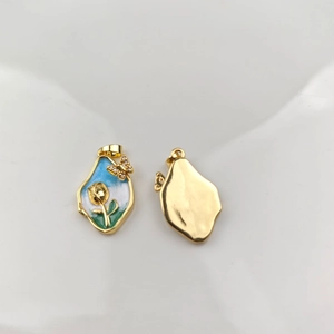 Detail view of gold enamel rose flower pendant with blue inlay and crystals