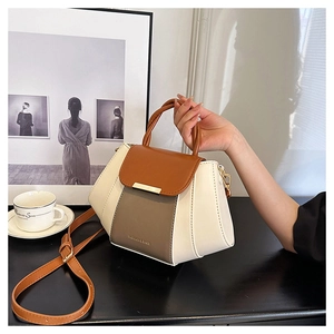 Detail of a color-block small square handbag with top handle and elegant textures