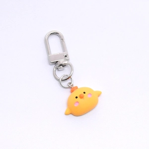 Close-up of a cute yellow chick resin keychain with metal ring and hook for bags