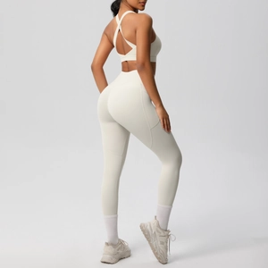 Detail of off-white yoga set featuring cross-back sports bra and high-waisted leggings with pockets