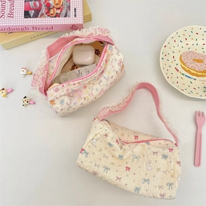 Close-up of quilted floral canvas handbag with lace trim and bow patterns