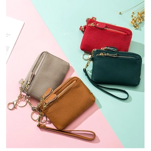 Flat lay of four colorful pebble leather coin purses with wrist straps and key rings