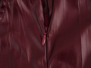 Dettaglio della trama in pelle PU rosso scuro e della cerniera invisibile in tinta