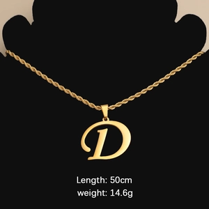 Detail of gold letter D pendant on a twisted chain necklace worn on a black bust