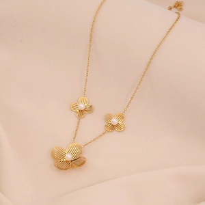 Détail du collier de fleurs dorées avec trois pendentifs orné de perles élégantes
