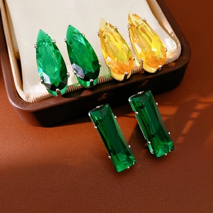 Detail of teardrop and square green zircon earrings in a premium brown leather jewelry box