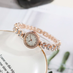 Detailed view of rose gold mermaid bracelet watch with diamond-set leaf links and round dial