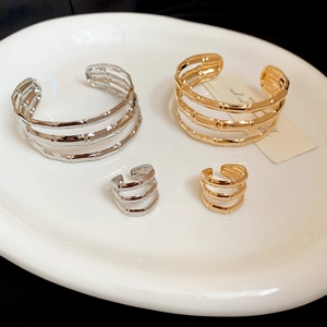 Macro detail of gold and silver multi-layer metal bangles and rings with bamboo texture