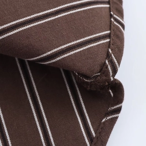Close-up of brown striped fabric showing detailed stitching and textured folding finish