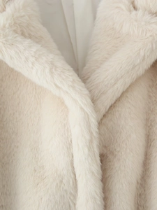 Close-up of fluffy cream faux fur collar texture and plush material on the coat
