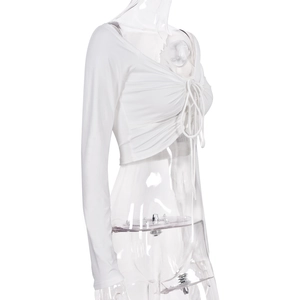 Dettaglio di un crop top bianco a maniche lunghe con coulisse anteriore e trama arricciata