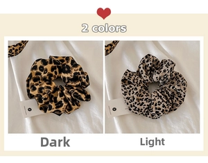 Detail of leopard print scrunchies in dark and light patterns on white fabric background