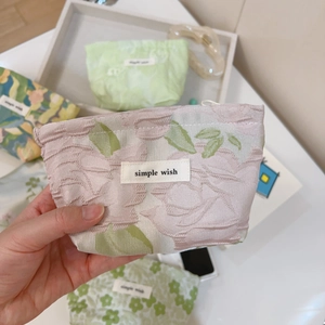 Close-up of floral jacquard canvas mini pouch with secure zipper and woven label