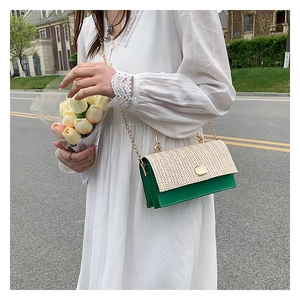 Détail du sac bandoulière en paille tressée avec corps vert et chaîne dorée