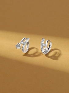 Detailed macro view of 18k silver plated star earrings with sparkling zircon accents