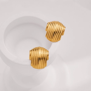 Macro detail of gold-plated stainless steel earrings with textured stripe pattern
