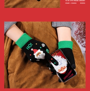 Detail showing knit touch screen gloves with Santa Claus pattern and ribbed green cuffs