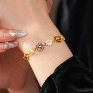 Detailed shot of vintage gold bracelet featuring tiger eye stones and zircon sunburst charms