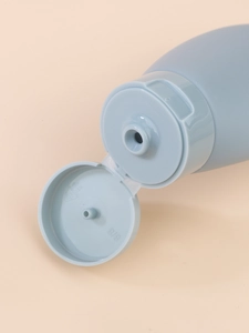 Close-up of the light blue travel bottle cap with flip-top open and nozzle detail