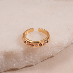 Macro detail of gold adjustable rings set featuring pink and purple geometric crystals