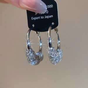 Detail view of silver U-shaped hoop earrings with pavé set rhinestones on black hanger card