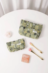 Detail of floral embroidery on light green linen cosmetic bags with premium hardware