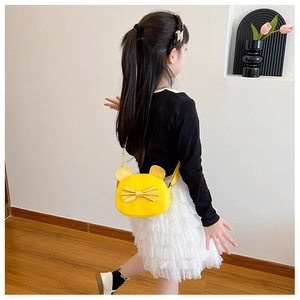 Toddler model wearing a yellow round crossbody bag with cute 3D ears and bow decoration